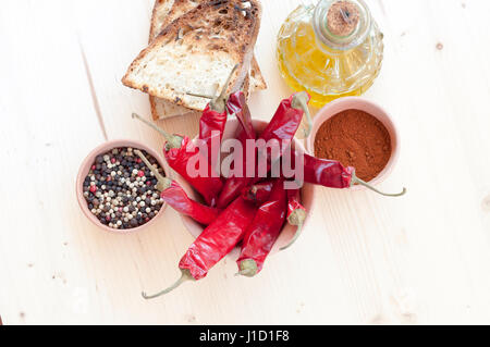 Peperoncino rosso, olio, il pane e il pepe in un vaso di argilla Foto Stock