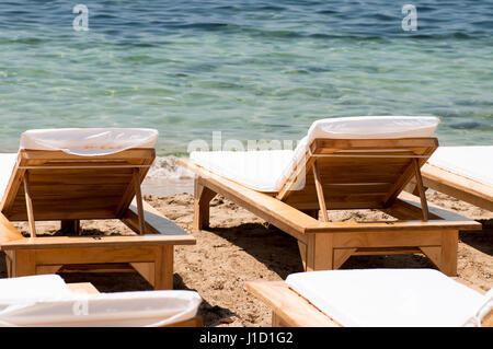 Sedie a sdraio sulla spiaggia vicino al mare Foto Stock