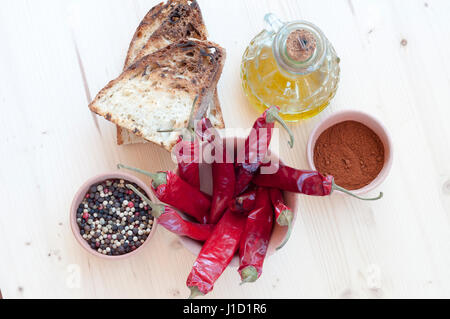 Peperoncino rosso, olio, il pane e il pepe in un vaso di argilla Foto Stock