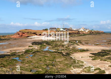 Isola di Hilbre visto dall'estremità sud a bassa marea con la gente che camminava sull'isola - situato nella bocca del fiume Dee Estuary Wirral REGNO UNITO 5 Marzo Foto Stock