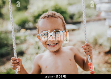 Giovane ragazzo di colore si diverte sul distributore rotazione Foto Stock