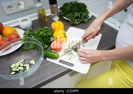 Donna con le mani in mano il taglio di verdure fresche. Foto Stock