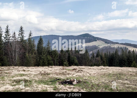 Wielka czantoria da mala czantoria collina di Beskid Slaski montagne sopra resort di Ustron in Polonia durante la giornata di primavera con il cielo blu e nuvole Foto Stock