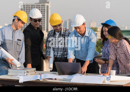 Il gruppo di ingegneri e architetti discutere in un cantiere, architettura e ingegneria concetto Foto Stock