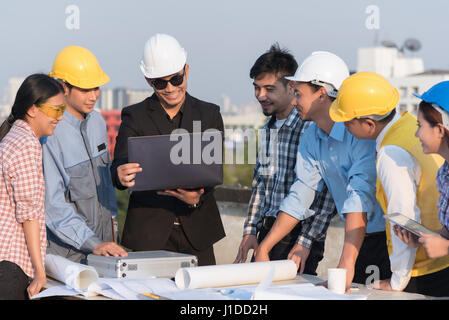 Il gruppo di ingegneri e architetti discutere in corrispondenza di un sito in costruzione Foto Stock