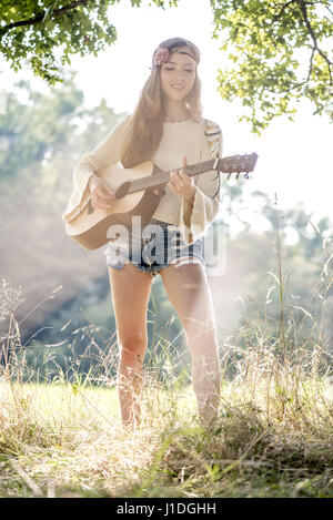 Giovane cantautore musicista chitarra ragazza in autunno la foresta, Vienna, Austria (modello-rilasciato) Foto Stock