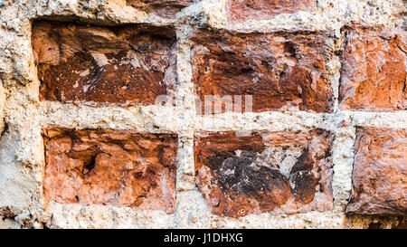 Vecchio Vintage Distressed rosso mattone verticale di parete Texture. Squallido marrone - rosso Brickwall background urbano. Grungy Street esterno Stonewall superficie. Abstract solido accidentato ruvida Foto Stock