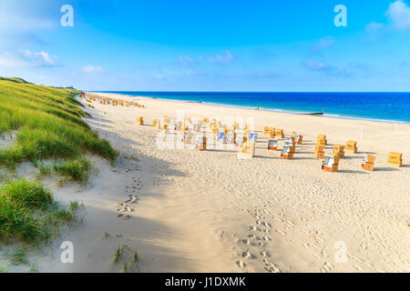 Erba sulle dune di sabbia e sedie di vimini su Wenningstedt beach, isola di Sylt, Germania Foto Stock