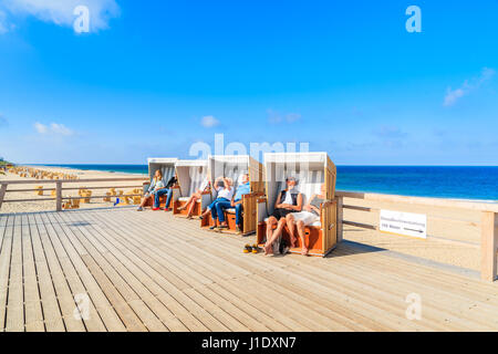 Isola di Sylt, Germania - Settembre 6, 2016: persone sedute in sedie di vimini sulla passeggiata costiera a Wenningstedt village. Foto Stock