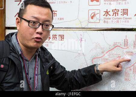 Guizhou, Cina. I giovani cinesi Han Man, di una guida turistica a il frutto giallo Tree (Huangguoshu) Cascata Scenic Area. Foto Stock