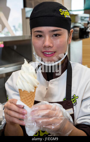 Guizhou, Cina. Han giovane donna cinese di vendita di gelato in una banchina di riposo. Foto Stock