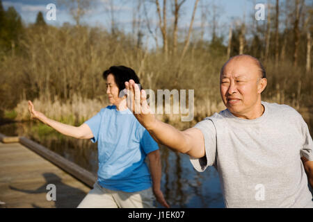 Un colpo di un senior asian giovane praticare il tai-chi esercizio Foto Stock