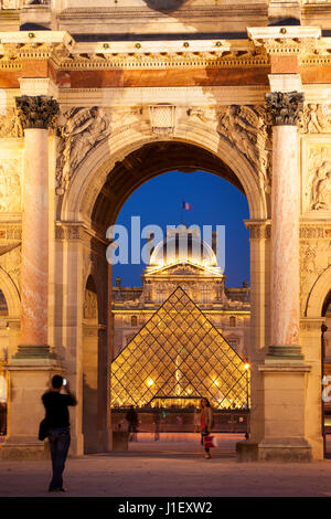 I turisti scattano foto all'Arc de Triomphe du Carrousel con il Musee du Louvre Beyond, Parigi, Francia Foto Stock