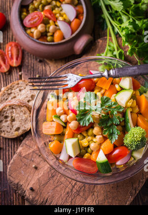 Insalata di verdure nella ciotola di vetro sul rustico naturale desk. Foto Stock