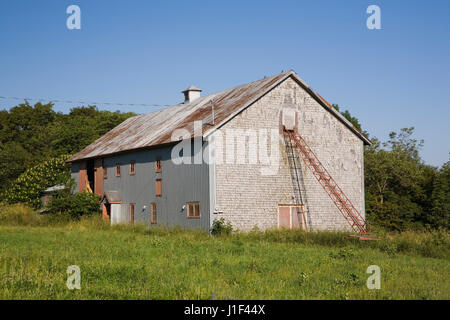Vecchio grigio e marrone a stalla per la memorizzazione di fieno, Saint-Francois, Ile d'Orleans, Quebec, Canada. Foto Stock