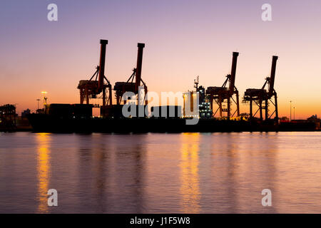 Silhouette di merci a nave e contenitore di carico e la gru al porto per la logistica e il trasporto dello sfondo. Foto Stock