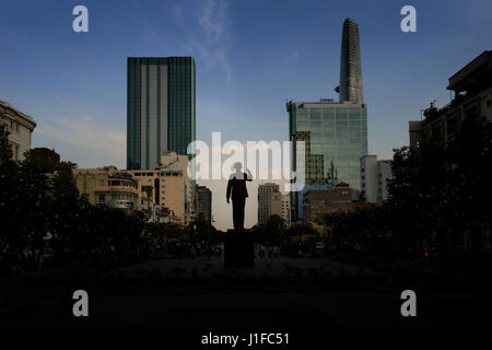 Il profilarsi la statua di Ho Chi Minh (Zio Ho) che si erge a Ho Chi Minh piazza contro lo sfondo della moderna città di Ho Chi Minh skyline. Foto Stock