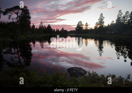 Mistica luce del tramonto riflettendo sul fiume silenzioso in nordic paesaggio subalpino Foto Stock