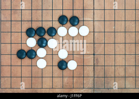Vista dall'alto nero e pietre bianche a giocare con base in joseki conner andare sulla scheda di gioco, cinese tradizionale strategia gioco di bordo, sport e hobby recreat Foto Stock
