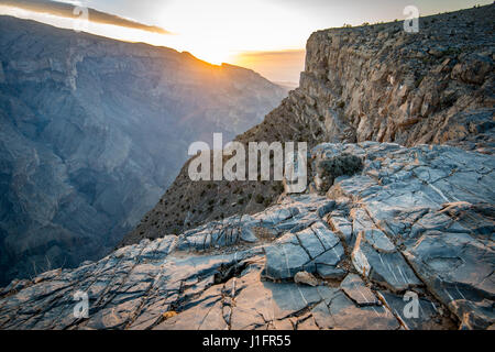 Jebel Shams; sole risplende nel corso del vertice e gorge in Oman il Grand Canyon Foto Stock