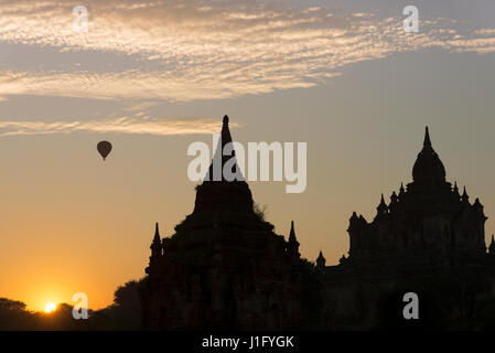 Mongolfiera sopra Tha Beik Hmauk Gu Hpaya presso sunrise, Bagan, Myanmar Foto Stock