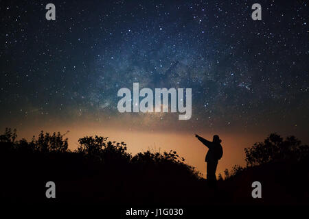 Un uomo è in piedi accanto alla via lattea puntando su una stella luminosa a Doi Luang Chiang Dao di alta montagna in Chiang Mai Provincia, Thailandia. Foto Stock