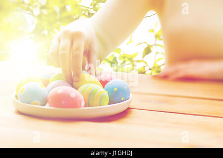 Close up della donna le mani con colorate uova di pasqua Foto Stock