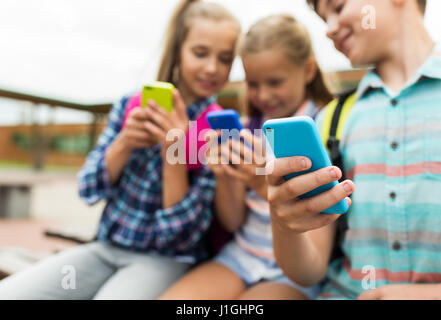 Gli studenti della scuola elementare con gli smartphone Foto Stock