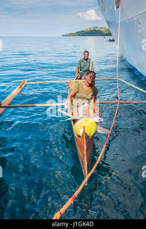 Hell-Ville, Madagascar - 19 Dicembre 2015 : malgascio fornitori da loro canoe outrigger offrono pesce e frutti tropicali di nave passeggeri presso Hell-Vill Foto Stock