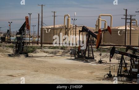 Pompa olio martinetti e il petrolio greggio dei serbatoi di stoccaggio nel fiume Kern Campo dell'olio lungo la valle di San Joaquin, 11 aprile 2017 a Bakersfield, California. I pozzi di petrolio e gas che coprono la zona sono su terreni pubblici affittati dalla Federal Bureau of Land Management. Foto Stock