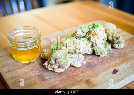 Ali Thai (Thai ali di pollo) servita su un tagliere da Ayden Kitchen & Bar a Saskatoon, Saskatchewan, Canada. Foto Stock