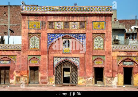 Weathered arco laterale con kashikari affreschi e piastrelle e porte a Mogul era Wazir Khan moschea a Lahore in Pakistan Foto Stock