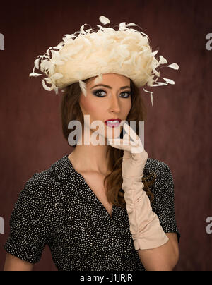 Giovani brunette modello in un vintage white cappello piumato Foto Stock