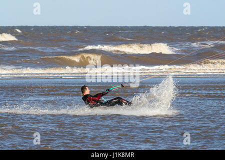 Ainsdale, Merseyside, 22 aprile 2017. Regno Unito Meteo. Un freddo vento del nord non interrompere questo coraggioso kite surfer da ottenere waist deep nel Mare d'Irlanda come egli rende la più soleggiata per iniziare la giornata sulla spiaggia Ainsdale nel Merseyside. Credito: Cernan Elias/Alamy Live News Foto Stock