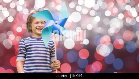 Composito Digitale di Felice ragazzo tenendo la girandola contro bokeh di fondo Foto Stock