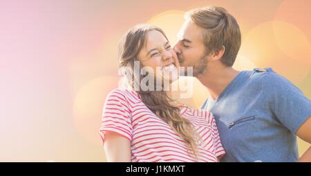 Composito Digitale di amare l uomo baciare donna felice sulla giornata di sole Foto Stock