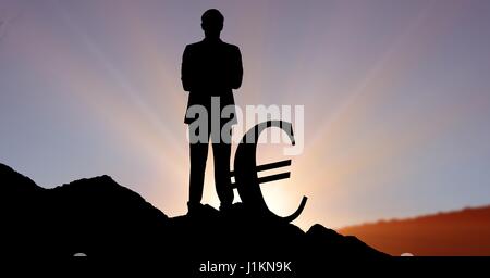 Composito Digitale di Silhouette uomo d affari in piedi accanto al simbolo dell'euro sulla collina contro sky Foto Stock
