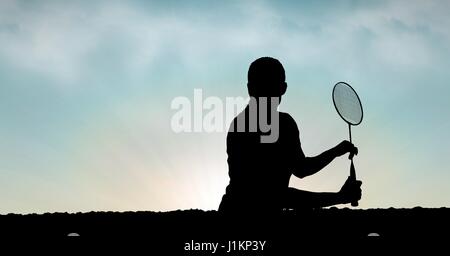 Composito Digitale di Silhouette uomo giocando badminton contro sky Foto Stock