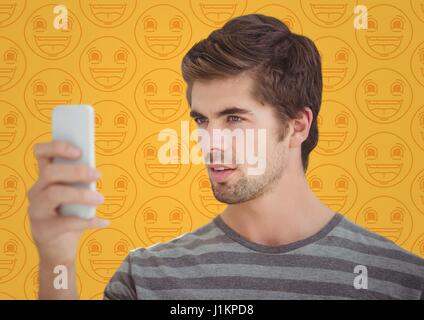 Composito Digitale dell'Uomo con telefono contro giallo modello emoji Foto Stock