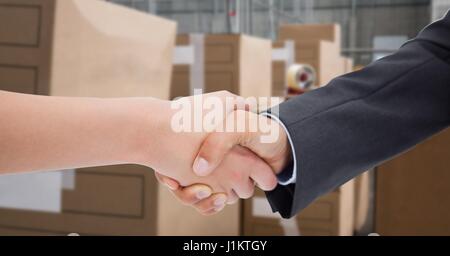 Composito Digitale di immagine ritagliata della gente di affari facendo handshake in magazzino Foto Stock