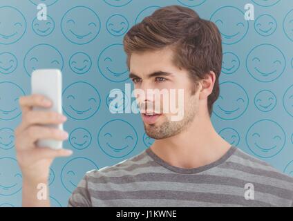 Digital composito di Mant con telefono contro blu modello emoji Foto Stock