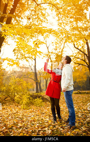 Matura in amore cercando di alberi con foglie di giallo in autunno nel parco Foto Stock