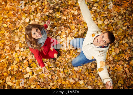 Allegro fidanzata con partner godendo nel parco sulle foglie cadute in autunno Foto Stock