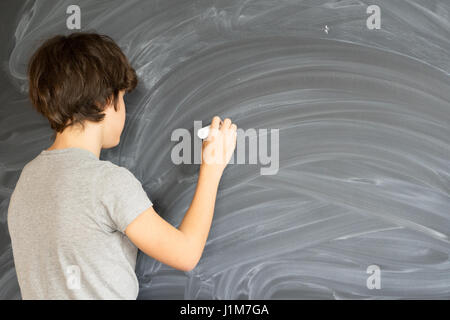 Ragazzo di scrittura sulla scheda nero Foto Stock