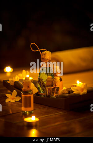 Bottiglie di olio da massaggio, spa con candele Foto Stock