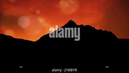 Composito Digitale della montagna di Silhouette contro il cielo arancione Foto Stock
