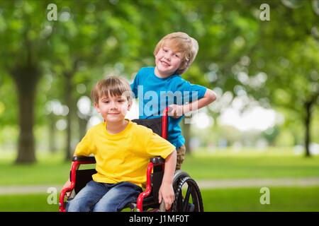 Composito Digitale del ritratto di ragazzo spingendo fratello in sedia a rotelle Foto Stock