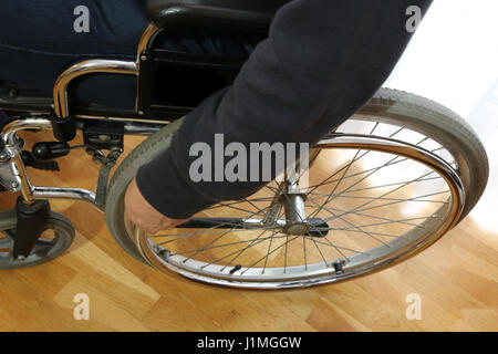 Dettaglio della sedia a rotelle in camera da letto in legno con pavimento in parquet Foto Stock