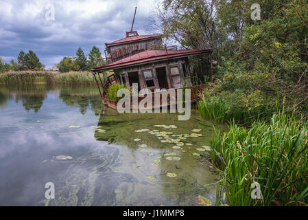 Naufragio barca su un Yanov backwaters nel pripjat città fantasma della centrale nucleare di Cernobyl la zona di alienazione intorno al reattore nucleare disastro, Ucraina Foto Stock