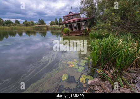 Naufragio barca su un Yanov backwaters nel pripjat città fantasma della centrale nucleare di Cernobyl la zona di alienazione intorno al reattore nucleare disastro, Ucraina Foto Stock
